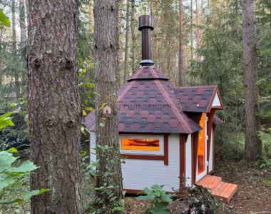 Финский гриль домик Кота Хаус 9 м2, вид сбоку на окно в лесу, закрытая беседка с грилем внутри