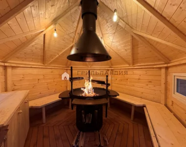 Интерьер финского гриль домика Кота Хаус 9 м2 с работающим центральным грилем и деревянными скамейками